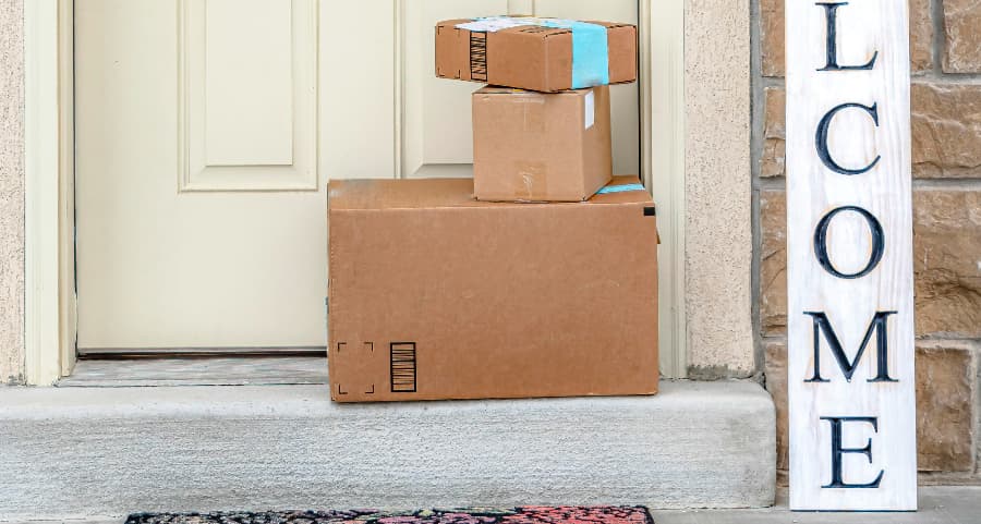 Packages on the doorstep of a home with a welcome sign in Sugarland